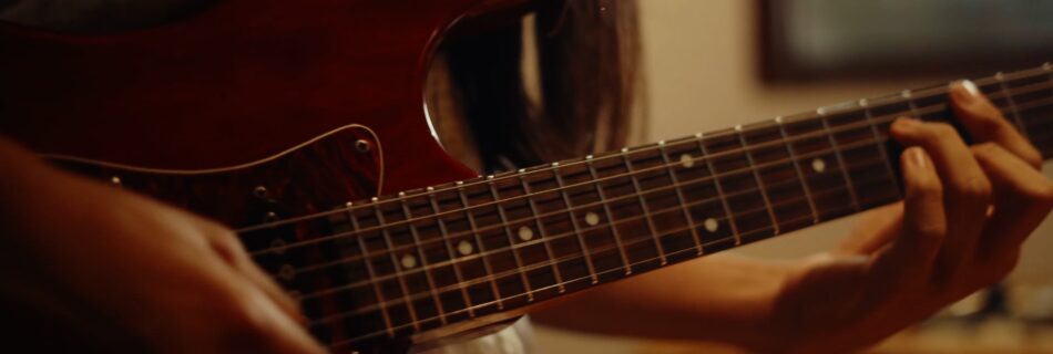 Detalle de guitarra eléctrica de sesión en estudio de producción musical durante grabación de Grupo Bahía